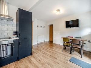 a kitchen with a table and a black refrigerator at Riviera Cottages in Sewerby