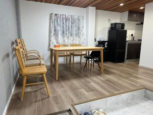 a table and chairs in a room with a kitchen at 寬居 kuanju 一棟貸し 広々一戸建て JR桜ノ宮駅徒歩3分 最大8名 梅田 大阪城公園アクセス良好 in Osaka