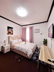 une chambre avec un grand lit et une table dans l'établissement EA3 Affordable Apartment Room Transient House Near SM Ecoland, Davao Coastal Road and Ecoland Bus Terminal, à Davao