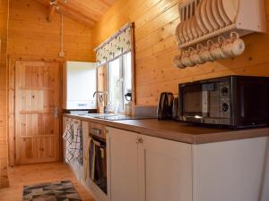 una cocina con microondas y encimera en Pheasant Lodge - Uk33402, en Hungerton