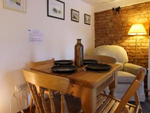 a wooden table with four empty plates on it at Hollyhocks Cottage in Docking