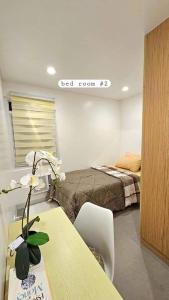 a bedroom with a bed and a table with a flower on it at Your Happy Place in Batulao Artscapes - 2Br near Twin Lakes Tagaytay in Calo +9 photos