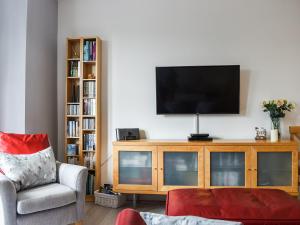 a living room with a television on a wooden entertainment center at Flat 3 Avon Villa in Bradford on Avon