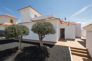 a white house with two trees in the driveway at Home2Book Luxury Villa Escape, Private Pool & BBQ in Antigua