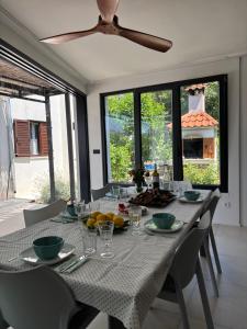 a dining room with a table with chairs and a ceiling fan at Villa LeANN in Okrug Donji