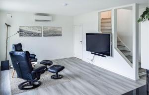 a living room with a chair and a television at 4 Bedroom Cozy Home In Hol I Tjeldsund in Dragland