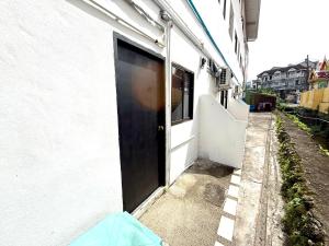 une porte ouverte d'un bâtiment blanc avec une rue dans l'établissement Patong Canal Villa R101, à Patong Beach