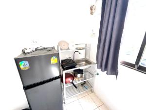 une petite cuisine avec un réfrigérateur et un évier dans l'établissement Patong Canal Villa R101, à Patong Beach