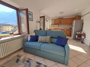 a blue couch in a living room with a kitchen at VILLA ADRY Aosta Sarre Your freedom in Aosta