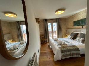 una camera con due letti e un grande specchio di Appartement 6 pers avec piscine, spa et parking - Pied de pistes - FR-1-461-5 a Saint-Martin-de-Belleville Altre 23 foto