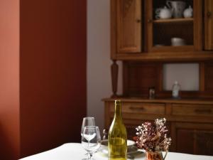 stół z butelką wina i dwoma kieliszkami w obiekcie Gîte confortable avec Wi-Fi, sauna, proche activités nature - FR-1-410-472 w mieście Saint-Léonard-des-Bois