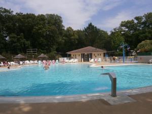 a large swimming pool with people in the water at Mobilhome 3 chambres tout confort, proche de la plage in Saint-Brevin-les-Pins
