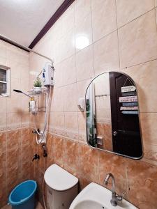 a bathroom with a mirror and a toilet and a sink at EA4 Furnished Transient Room Apartment House Walking Distance to SM Ecoland & Davao Coastal Road and Near Ecoland Bus Terminal in Davao City +6 photos