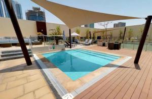 a swimming pool with an umbrella on top of a building at Stylish 1BR at Damac Maison -Your Grand Canal Getaway in Dubai