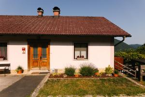 una piccola casa bianca con tetto marrone di Eko Homestead Luka - Escape Room, Archery, BBQ, Rafting and more - a Vrh pri Fari