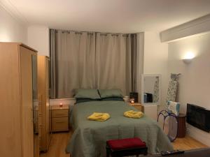 una camera da letto con un letto grande e una televisione di The Oxford St Stay a Londra