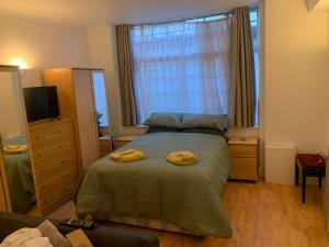 una camera da letto con un letto con due asciugamani gialli di The Oxford St Stay a Londra