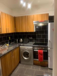 una cucina con lavatrice e piano cottura di The Oxford St Stay a Londra