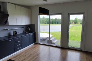 a kitchen with a large sliding glass door leading to a patio at Brīvdienu māja Dīķmalas in Indiņi