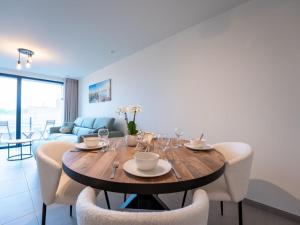 a dining room with a wooden table and chairs at Apartment Elyana with balcony by Interhome in Blankenberge +13 photos