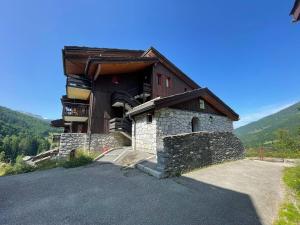 un bâtiment avec un balcon sur le côté dans l'établissement Studio skis aux pieds à Valmorel, proche ESF et commerces, animaux acceptés - FR-1-356-180, à Valmorel