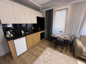 a kitchen and living room with a table in a room at Güven Palace Suites in Sürmene