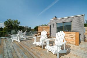 a deck with white chairs and a table and a building at room with shared bathrooms 883 Shefford in Bromont