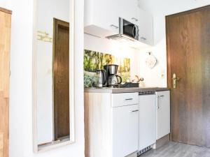 une cuisine avec des armoires blanches et un évier dans l'établissement Apartment Studio Esche 2 by Interhome, à Ellmau 47 autres photos