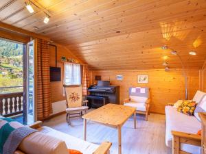 Una sala de estar de cabaña de madera con una mesa y un escritorio. en Apartment Berna 2- Stock by Interhome, en Lenk