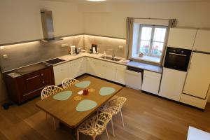 a kitchen with a wooden table with chairs and a sink at Tulpe Apartments in Vandoies di Sotto