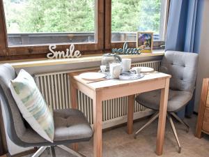 une table et deux chaises devant une fenêtre dans l'établissement Apartment Studio Esche 4 by Interhome, à Ellmau