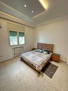 a bedroom with a bed and a table in it at villa meublé in Tunis