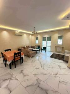 a large living room with marble floors and a table at villa meublé in Tunis