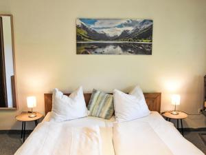 sypialnia z łóżkiem z białymi prześcieradłami i poduszkami w obiekcie Apartment Studio Esche 1 by Interhome w mieście Ellmau