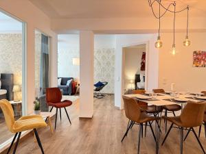 ein Esszimmer und ein Wohnzimmer mit Tisch und Stühlen in der Unterkunft Exklusives 3 Zi Design Apartment in FR-Altstadt in Freiburg im Breisgau