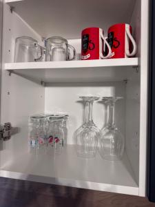 eine Reihe von Glasgefäßen und Tassen auf einem Regal in der Unterkunft Ianis Home in Hunedoara + 11 Fotos