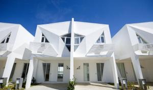 a white house with white columns and windows at Your Happy Place in Batulao Artscapes - 2Br near Twin Lakes Tagaytay in Calo
