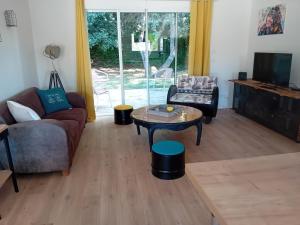 una sala de estar con un sofá y una mesa en Maison de vacance à la mer, en Les Sables-dʼOlonne