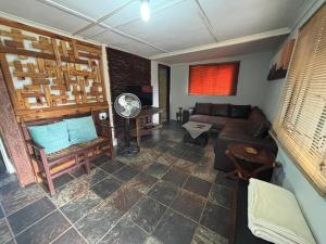 a living room with a couch and a fan at Jorstel in Grootvlei