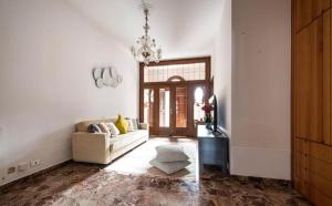 Una sala de estar con un sofá y una lámpara de araña. en Central Apartment Ca' dei Ferro - MURANO Venice, en Murano