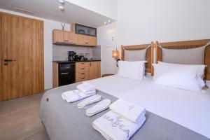 a bedroom with a large bed with towels on it at Marea Boutique Suites in Rethymno
