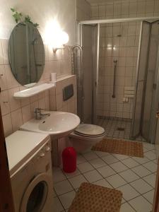 a bathroom with a sink and a toilet and a shower at Ferienhaus Seewind in Nordstrand