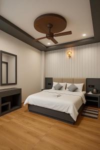 a bedroom with a large bed with a ceiling fan at The Narendra hotel 700m away from the Ram Mandir in Ayodhya
