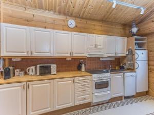 eine Küche mit weißen Geräten und Holzwänden in der Unterkunft Holiday Home Jerisrannantie 7 by Interhome in Rauhala + 13 Fotos