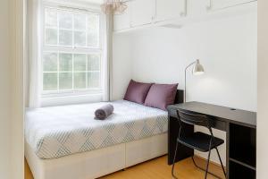 a small bedroom with a bed and a desk at Central London Stays in London