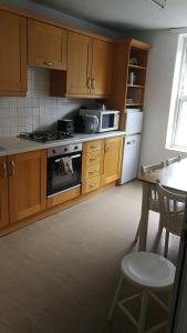 a kitchen with wooden cabinets and a table and a stove at Central London Stays in London