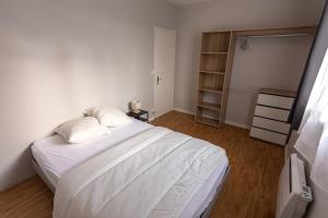 1 dormitorio con cama blanca y armario en Maison avec parking la Flocellière, en La Flocellière