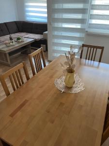 a dining room table with a vase with a plant on it at Apartment MJ in Čapljina