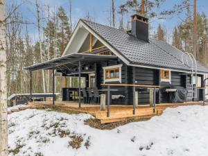 une cabane en rondins dans les bois dans la neige dans l'établissement Holiday Home Villa tintinmaja by Interhome, à Jyväskylä