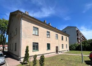 een groot bakstenen gebouw met een auto ernaast bij Blakus bērnu pilsētiņai un pludmalei in Ventspils